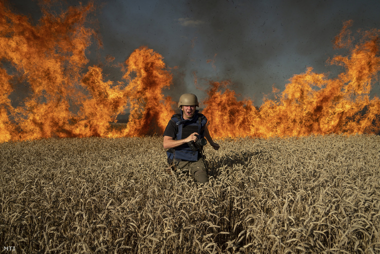 Jevhen Maloletka fotóriporter egy búzaföldön égő tűz elől fut a kelet-ukrajnai harkivi területen néhány kilométerre az orosz határtól, miután orosz rakétatámadás érte a térséget 2022