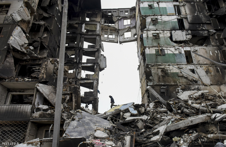 Férfi megy az orosz támadásokban megrongálódott lakóépület romjai között a Kijev közelében fekvő Borogyankában 2022