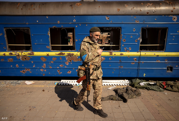Ukrán katona járőrözik egy szétlőtt vasútállomáson, Trostyanec városában 2022