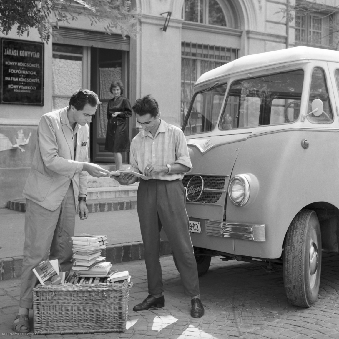 Cegléd, 1963. augusztus 27. Tamasi Tamás könyvtáros és Viniczai István gépkocsivezető összeválogatja a mozgó könyvtár könyveit a ceglédi járási könyvtár előtt. A háttérben Kányi Andrásné, a könyvtár vezetője