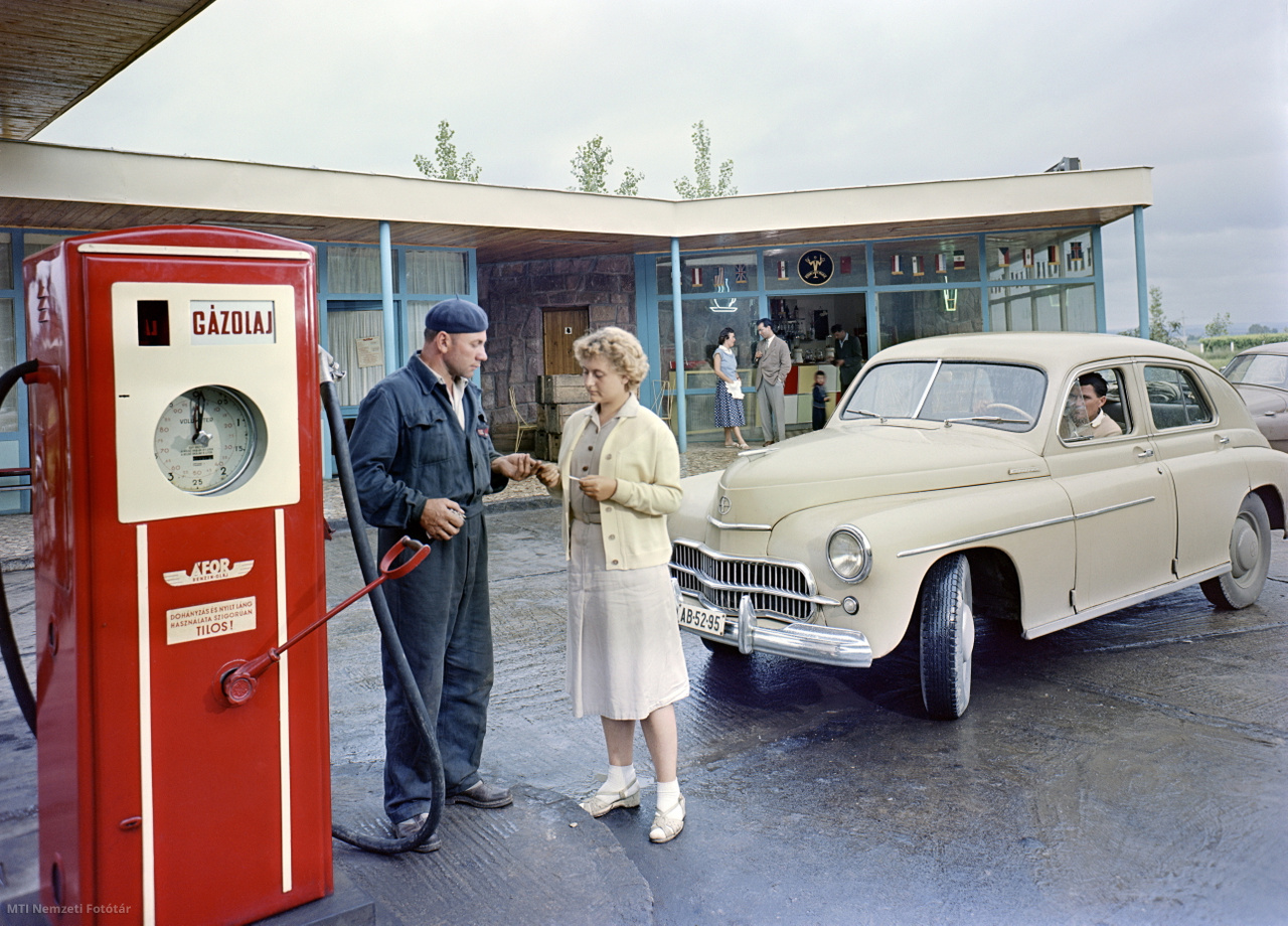 1959. július 23. Fiatal nő átadja a kifizetett üzemanyagról a pénztárblokkot a benzinkutasnak egy balatoni ÁFOR- (Ásványolajforgalmi Vállalat) benzinkútnál. Jobbra, egy Warszawa M201-es típusú gépkocsi várakozik a tankolásra. A felvétel készítésének pontos helye ismeretlen. 1957-ben jelent meg az ÁFOR embléma a kutakon és egészen a hatvanas évek közepéig kellett várni a multinacionális vállalatok (Shell, BP, Agip) újbóli megjelenésére a hazai utak mellett. (/MTI Nemzeti Fotótár)