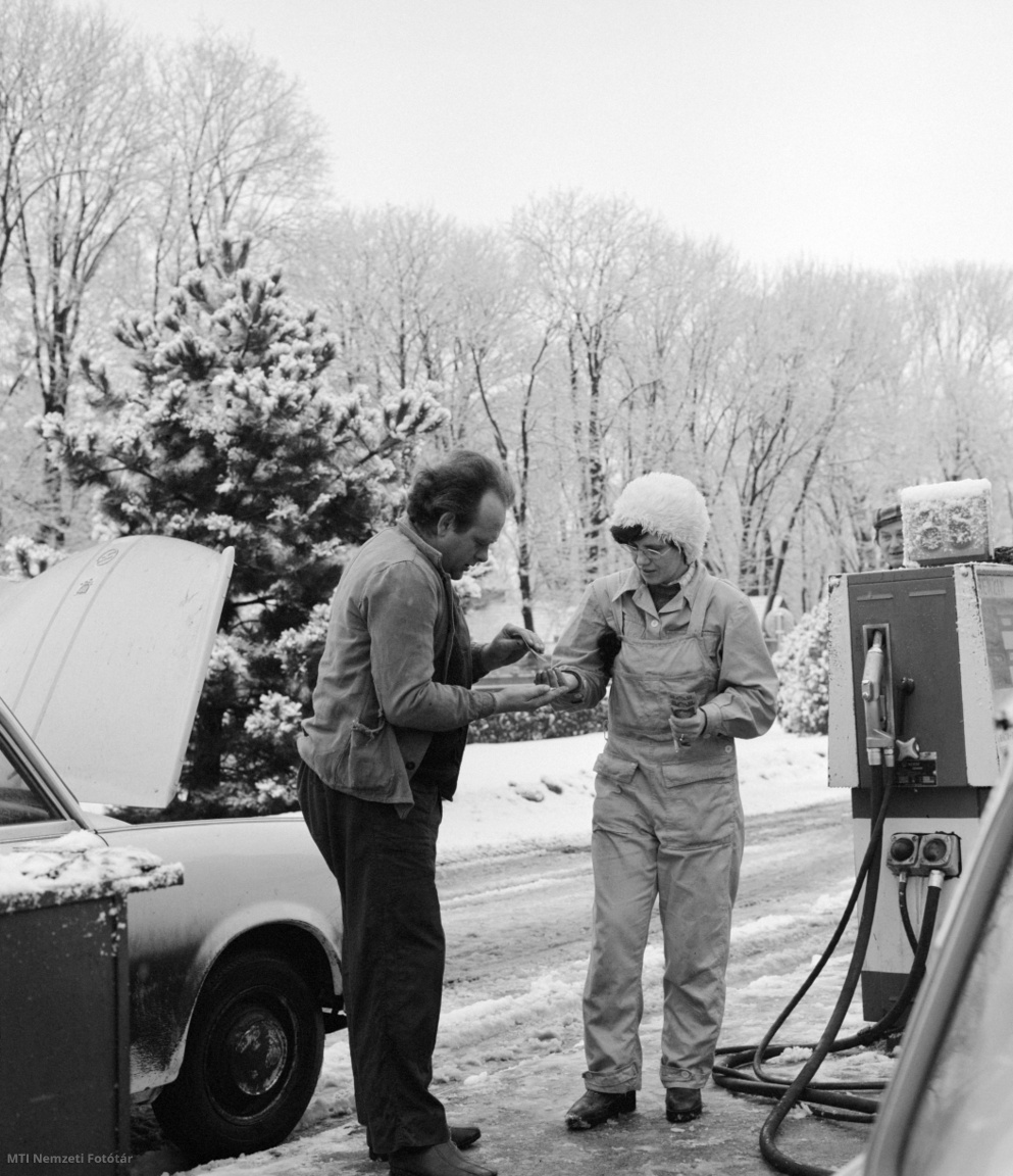 Dunabogdány, 1977. január 14. Egy Trabant személygépkocsi vezetője kifizeti a tankolást a kút kezelőjének. Az utak mentén a 70-es években még kisebb benzinkutak biztosították az autósok számára a tankolást. Az ÁFOR volt a nagy hazai forgalmazó. Kínálatába tartozott a 86 oktános benzin is. A Trabantba a benzinhez olajat adalékoltak (/MTI Nemzeti Fotótár)