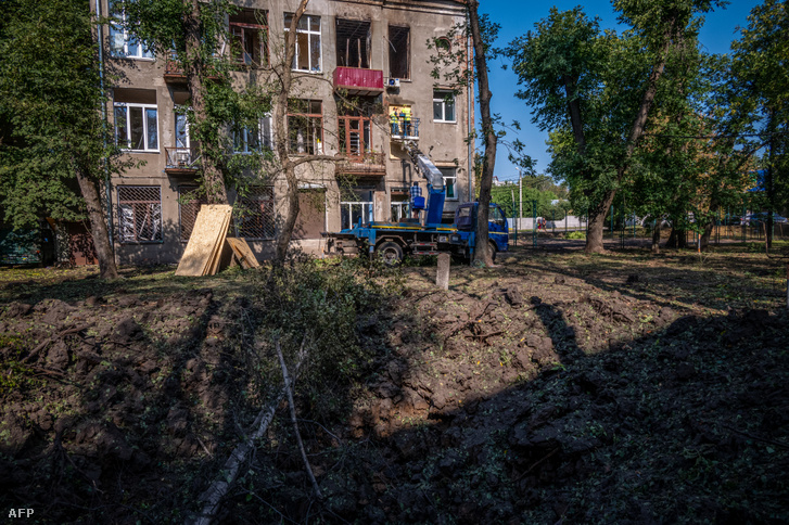 Egy rakétatámadásban megsérült ház ablakait deszkázzák be Harkivban 2022. augusztus 31-én