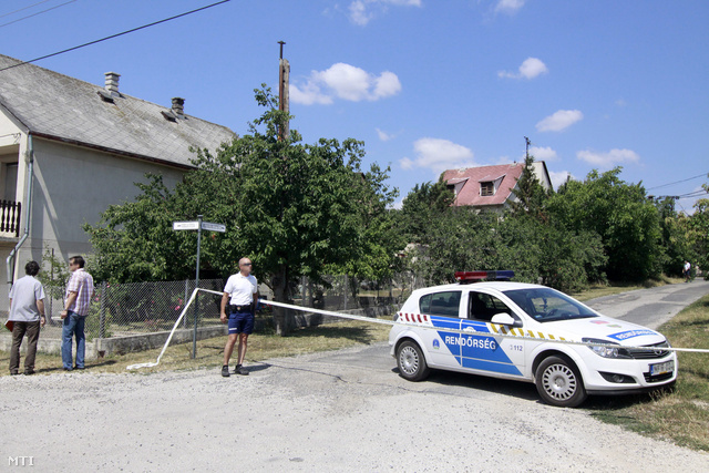 Rendőrök helyszínelnek Várpalotán a lezárt Krúdy Gyula utcánál, ahol egy 58 éves férfi sörétes vadászfegyverből több lövést leadva megölt egy férfit és egy nőt 2013. július 14-én, majd magával is végzett.