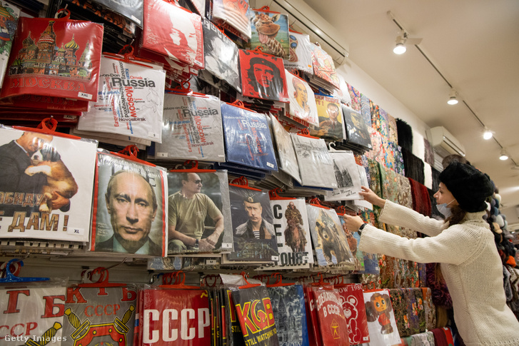 Vlagyimir Putyint ábrázoló pólókat pakol egy eladó egy turisták által kedvelt boltban Moszkvában