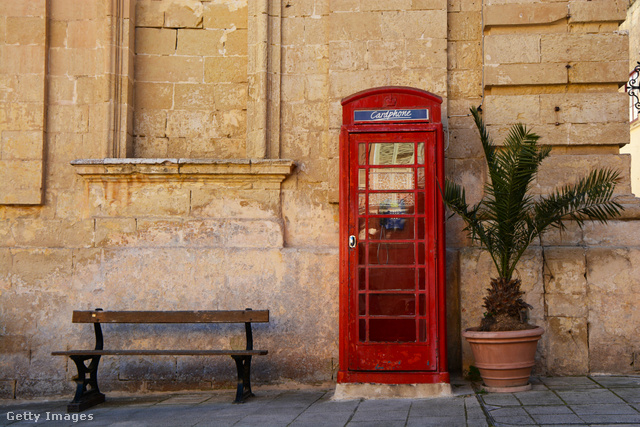 Kultúrák találkozása: brit telefonfülke az ódon falak tövében
