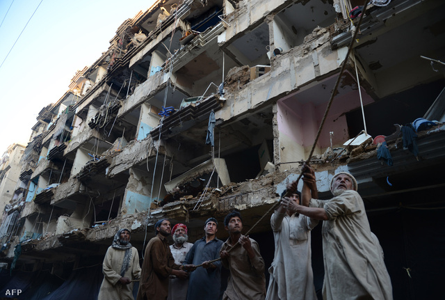 Kábelt húznak le egy romos ház földszintjére pakisztáni férfiak