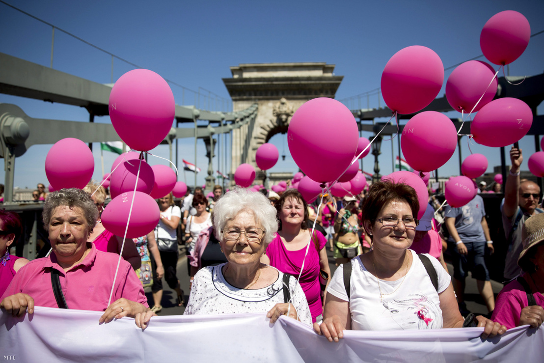 A mellrákellenes séta résztvevői rózsaszín lufikkal vonulnak a Lánchídon 2015. június 6-án