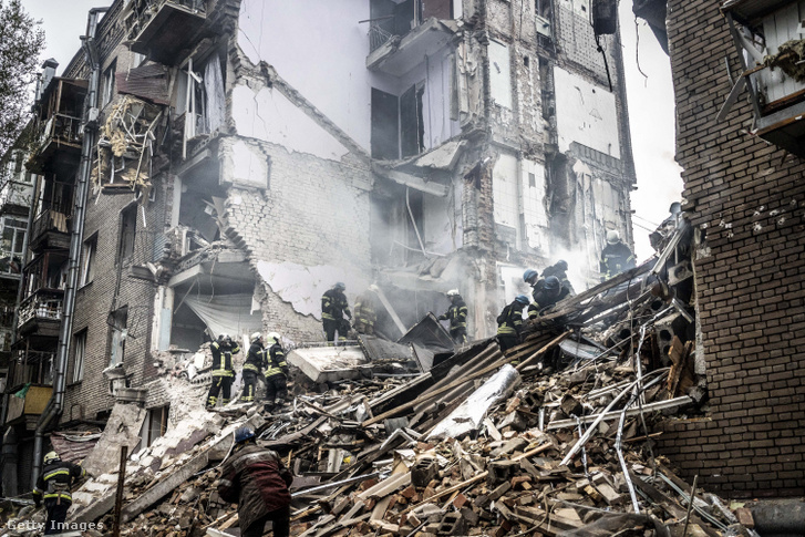 Tűzoltók dolgoznak egy megrongálódott épületben az orosz rakétatámadás után Zaporizzsjában, Ukrajnában 2022. október 10-én