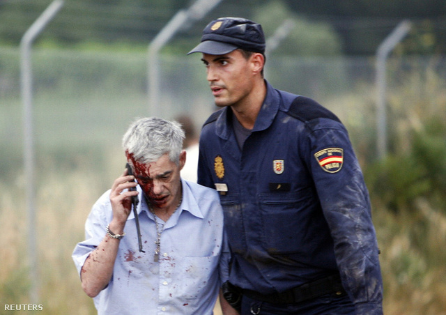 Francisco Garzont, a spanyol vonat vezetőjét támogatja egy rendőr a balesetet követően