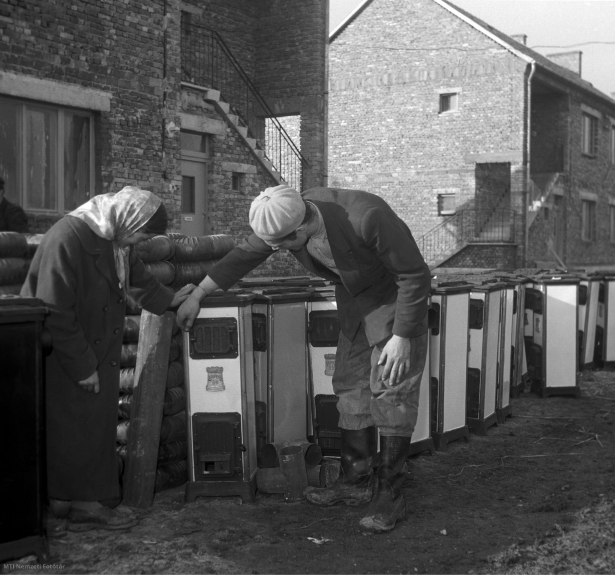 Edelény, 1957. december 21. Hajdu Károly kétgyermekes bányász feleségével az új kályhák között válogat az Edelény melletti új bányászlakótelepen, ahol egy két szoba-összkomfortos lakást kapott