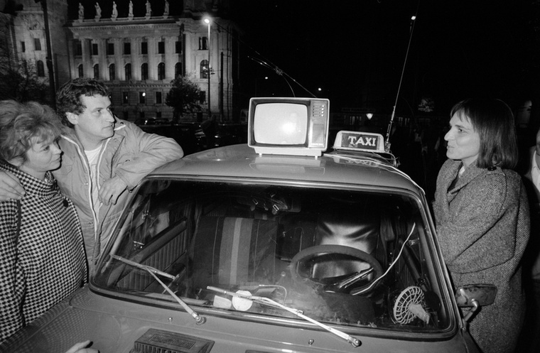 Az autó tetejére helyezett hordozható TV-n nézik a híradót a benzináremelés ellen tiltakozó taxisok a kormány és az érdekképviseletek tárgyalásainak eredményét várva a Kossuth téren
