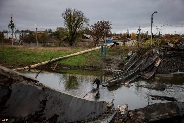 Egy férfi kel át egy lerombolt hídon Bahmutban 2022. október 27-én