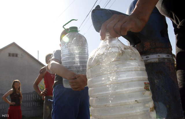 Emberek vizet vesznek egy leszűkített közkútból Ózd sajóvárkonyi településrészén 2013. augusztus 4-én.