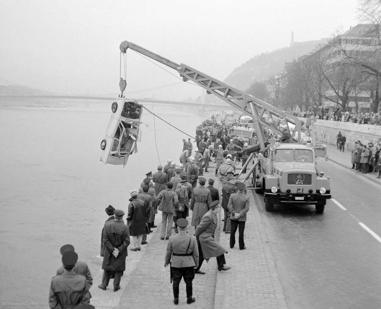 Budapest, 1970. november 14. Nézelődők kísérik figyelemmel, ahogyan a daru kiemeli a Lánchíd és az Erzsébet híd közötti budai partszakaszon Dunába esett Trabantot. A sofőr könnyebb sérülést szenvedett.
