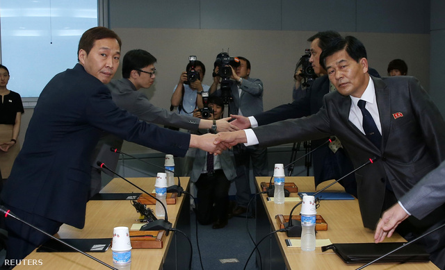 Szo Ho, a dél-koreai küldöttség vezetője (b) kezet fog észak-koreai partnerével, Park Csul Szúval a keszongi ipari park működésének felújításáról szóló tárgyalások kezdetén a panmindzsoni demilitarizált övezetben 2013. július 10-én.