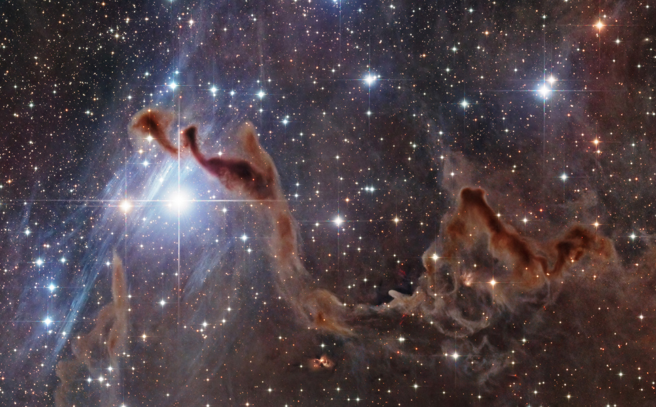 Kozmikus KézA különös kozmikus kezet a képen átívelő barnás sötétköd-komplexum formálja. Anyagát a Tejútrendszer csillagainak összeolvadó fénye deríti meg halványan, ennek köszönhetően válik láthatóvá. Porból és gázból álló ködösség, melynek sűrűbb részeiben már csillagok születnek. A felvétel mindezt rendkívüli mélységben és részletességgel mutatja meg, úgy, ahogy eddig még nem láthattuk