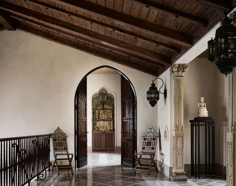 A fő hálószoba bejáratánál bronzzal díszített diófa ajtók, velencei vakolatú falak és két
                        összecsukható udvari szék található.