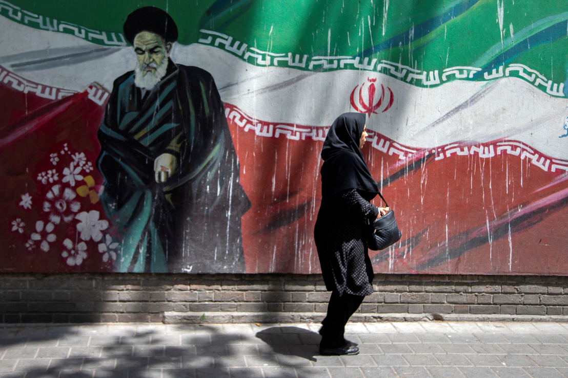 Egy nő sétál az ajatollah képe előtt Teheránban 2019 nyarán