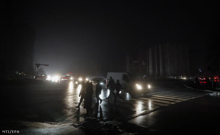 Sötétben kelnek át egy zebrán emberek áramszünet idején Kijevben 2022. november 24-én