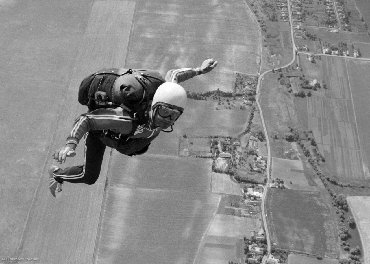 Szolnok, 1974. június 25. Samu Ferenc, a magyar ejtőernyős-válogatott edzője ugrás közben, stabil testhelyzetben. A háternyő oldalán jól látható a vészhelyzetben (kis magasság elérésekor) az ejtőernyő automatikus nyitását végző kapkészülék (kombinált ejtőernyős-biztosító készülék)