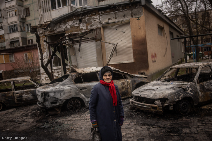 Helyi lakos az egyik éjszakai lövöldözés során megsérült lakóépüket előtt áll 2022. december 1-én Kherson Ukrajnában