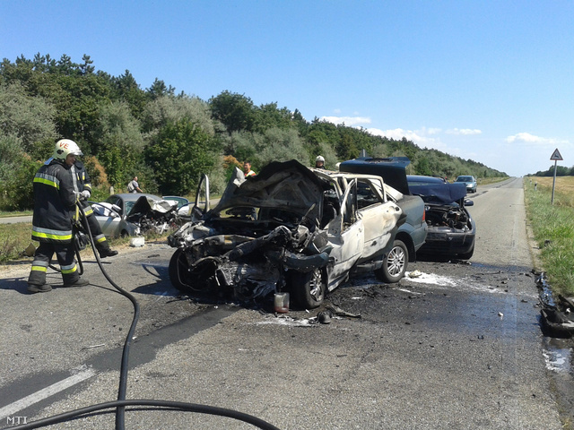 Tűzoltók dolgoznak a Szentkirályszabadja és Veszprém közötti úton, ahol három személyautó ütközött 2013. augusztus 15-én.