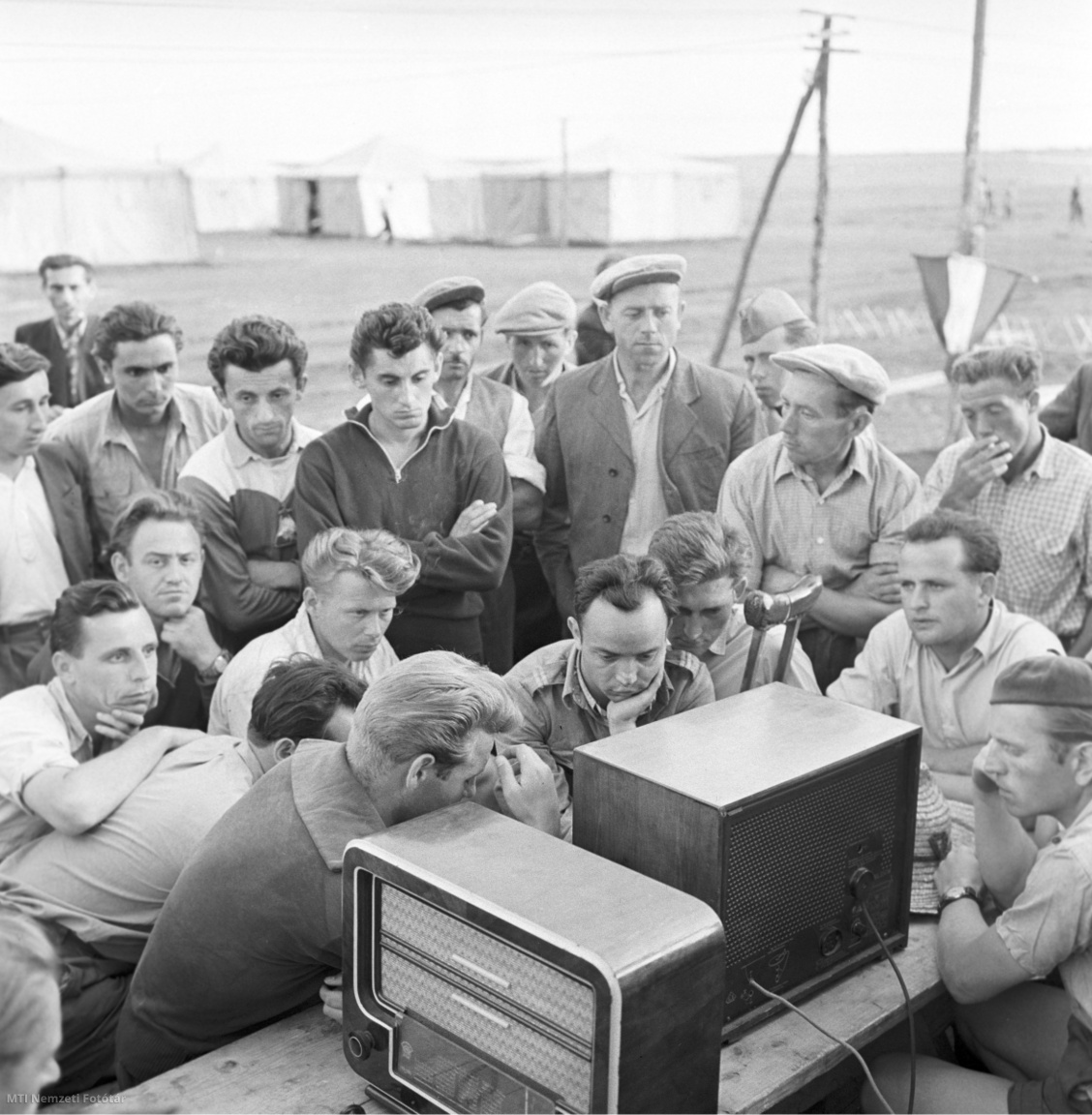 Kimle, 18 de junio de 1958. Los residentes del campamento escuchan la transmisión por radio del partido de fútbol entre Hungría y Gales.  Los miembros de KISZ del condado de Győr fueron los primeros en llegar para drenar las áreas pantanosas de Hanság.