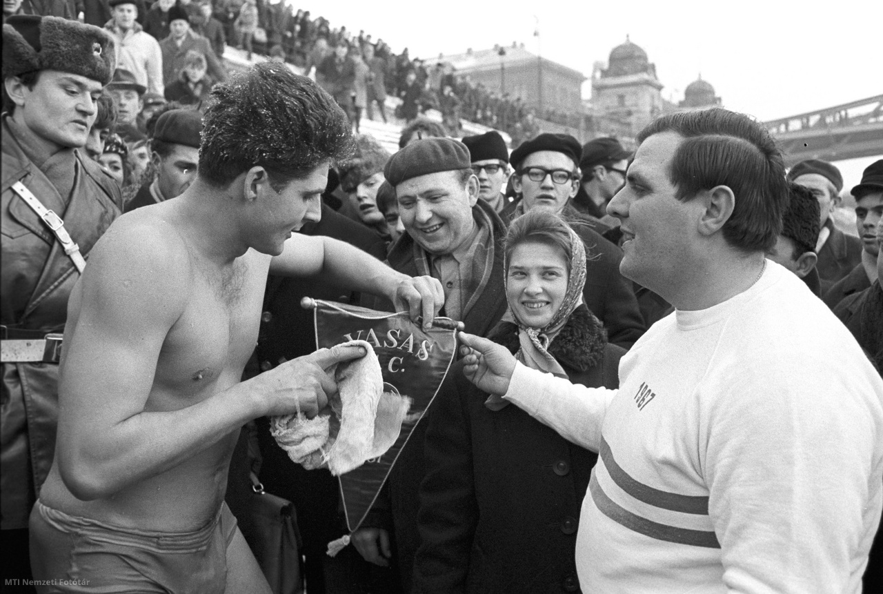 Budapest, 1968. január 12. Schirilla György (b), a Vasas sportolója egy ajándék Vasas-zászlót vesz át egy férfitól úszása után. A sportoló január 12-én 16 percet töltött a nulla Celsius-fokos jeges vízben –10 fokos levegő-hőmérsékletnél