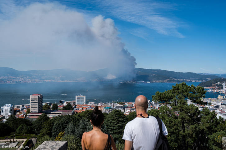 Egy erdőtűz füstjét néző pár Vigo városában, 2022 augusztusában