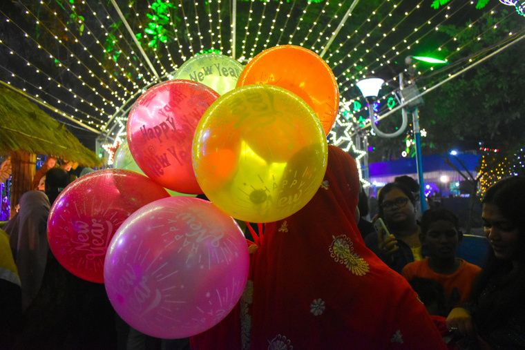 Egy nő színes lufikkal a kezében a kalkuttai karácsonyi vásárban. (Fotó: Sudipta Das/Northfoto)