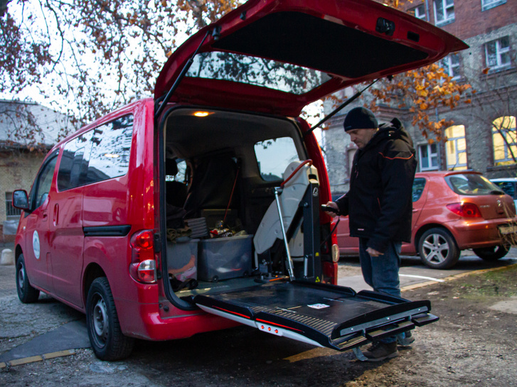 A piros Nissan NV200-at a csomagtér ajtó mögötti hidraulikus rámpa miatt többnyire speciális feladatokra, kerekesszékes emberek szállítására használják