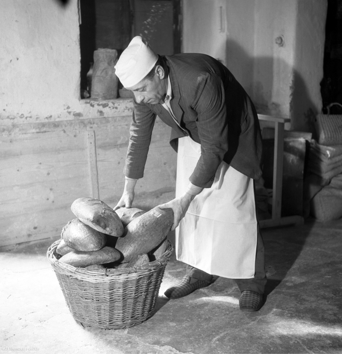 Budapest, 1948. március 9. Egy pék kosárba rakja a kisült kenyereket Bujáki György V. kerületi pékségében, a Fehérhajó utca 3. alatt