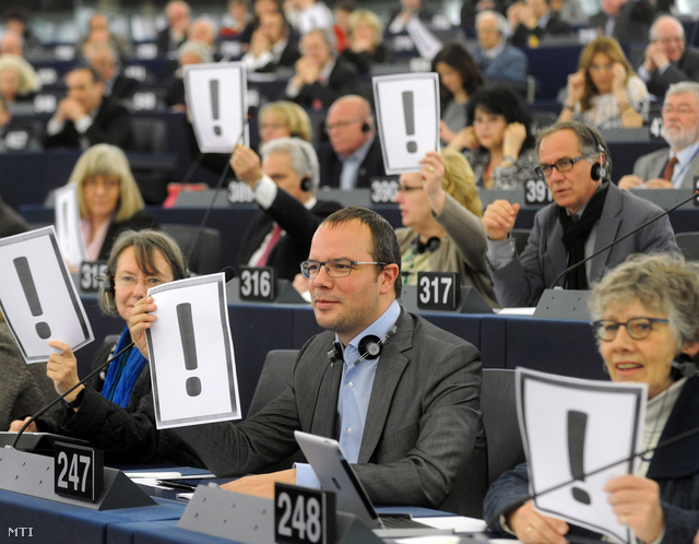 Az Európai Parlament (EP) képviselői felkiáltójelek felmutatásával tiltakoznak a magyar alaptörvény előző napon megszavazott negyedik módosítása ellen az EP plenáris ülésén Strasbourgban 2013. március 12-én.