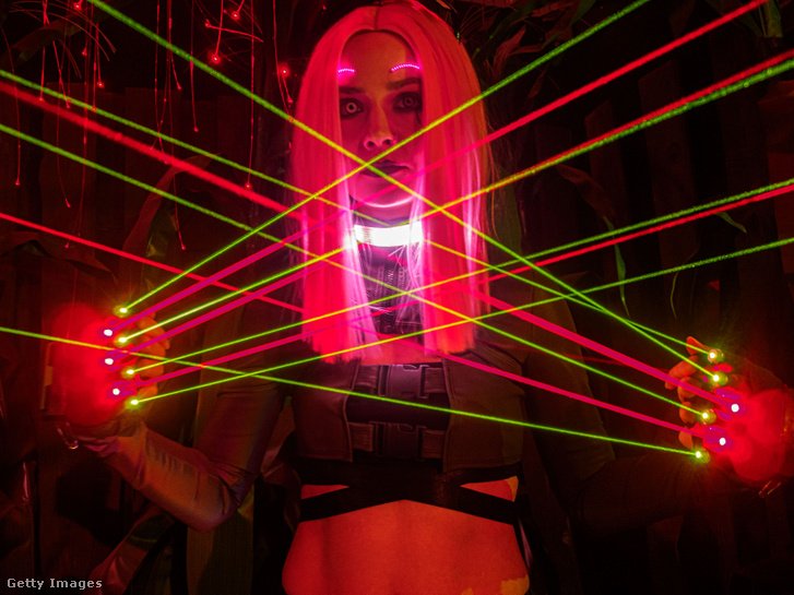 A Cyberpunk 2077 játék bemutatójára beöltözött coplayes hölgy pózol a jelmezébe épített lézerekkel, Moszkvában 2020 december 12-én
