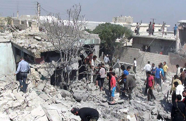 Az Edlib News Network (ENN) által közreadott amatőr képen romok között kutatnak emberek a szíriai hadsereg légitámadása után a Szíria északi részében fekvő Idlíb tartományban 2013. augusztus 30-án.