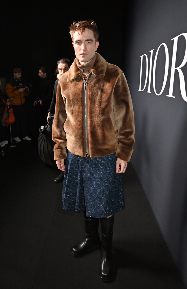Robert Pattinson egy sötétkék flitteres szoknyát viselt, felül pedig egy barna bundadzsekit.