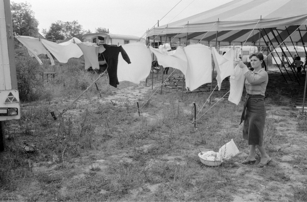 1981. szeptember 7. Egy asszony a mosott ruhát teregeti a vándorcirkusz körsátra mellett. 
