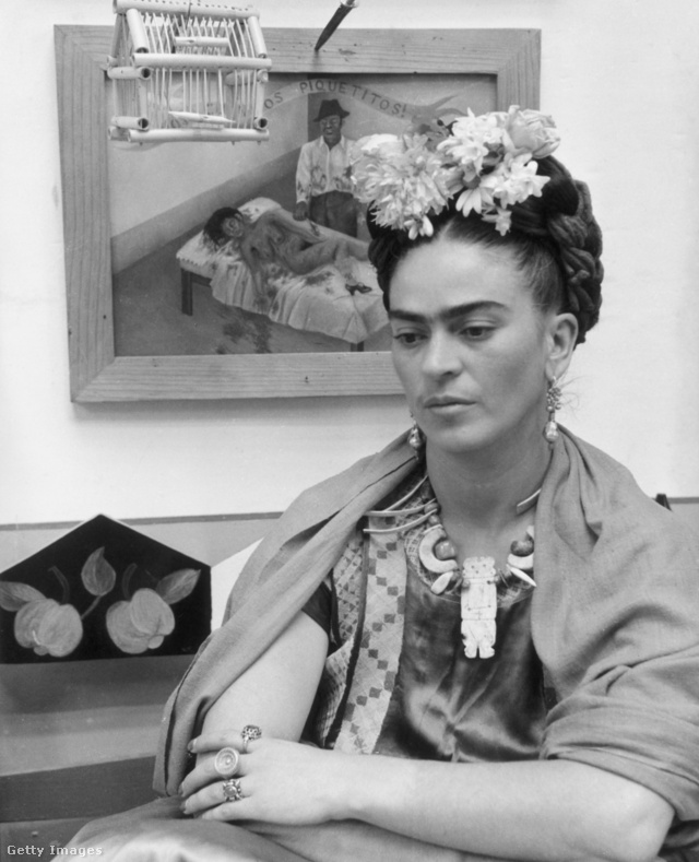 Frida 1945-ben az egyik festményével a háttérben