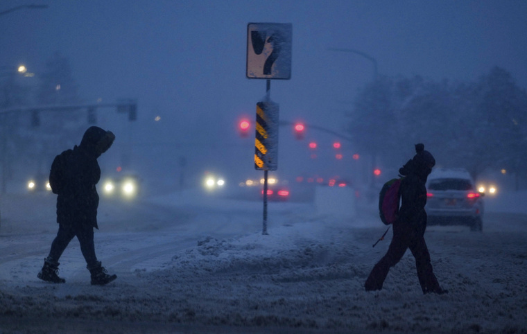Szakadó hóesésben gyalogolnak emberek a Utah állambeli Salt Lake Cityben 2023