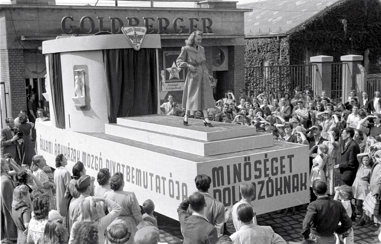 Budapest, 1948. szeptember 3. Utcai divatbemutatót rendeztek az állami áruházak. Mozgó színpadon mutatták meg az áruházi dolgozók a munkásnőknek a nekik szánt sokféle, olcsó és divatos ruhát.