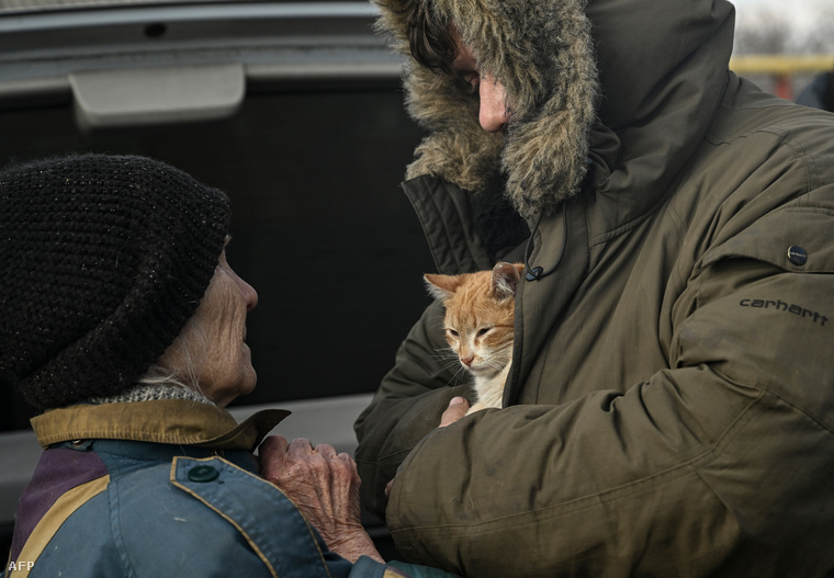 Ukrán katona macskával a karján, míg beszélget az utcán a Bahmut közeli Hasziv Jarban, 2023