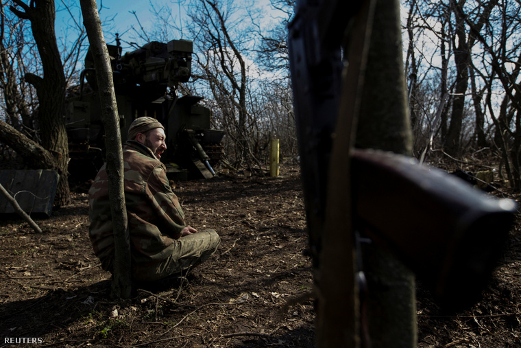 Ukrán katona pihen egy önjáró löveg mellett a bahmuti frontnál, 2023