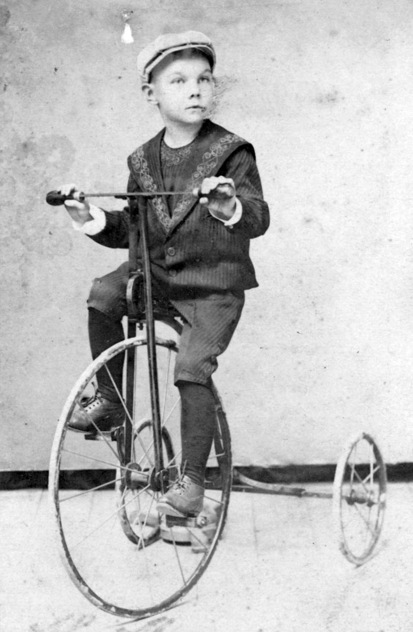 Egy erősen fapados tricikli 1900-ból. A saras kerekeket elnézve a járgányt nem csak a fotózáshoz használták.