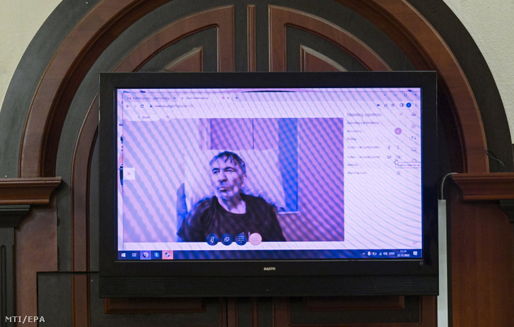 A hatalommal való visszaéléssel vádolt, éhségsztrájkot folytató Mihail Szaakasvili volt georgiai elnök (kivetítőn) videókapcsolaton keresztül vesz részt bírósági perének folytatásán Tbilisziben 2022. december 22-én