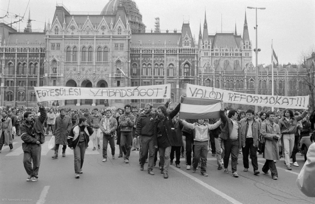 Budapest, 1988. március 15. Nemzeti zászlóval, valamint "Egyesülési Szabadságot!" és "Valódi Reformokat!" feliratú transzparensekkel vonuló fiatalok a március 15-ei ünnepségek alkalmával a Parlament előtt.