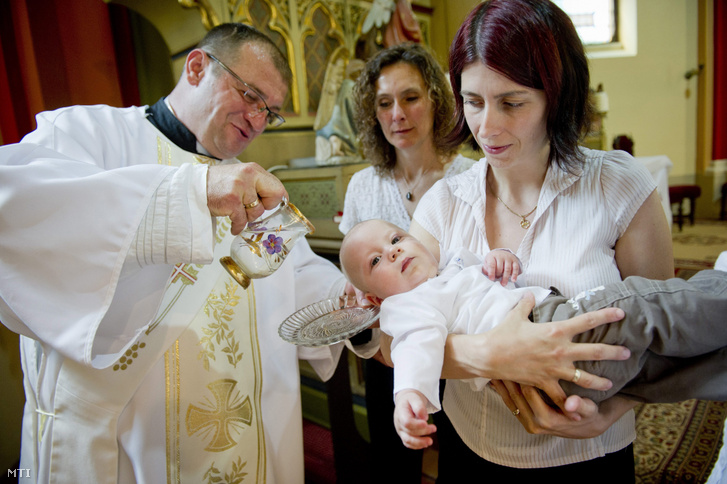 Maronka Lajos diakónus megkeresztel egy gyermeket Gádoroson, a Kisboldogasszony katolikus templomban