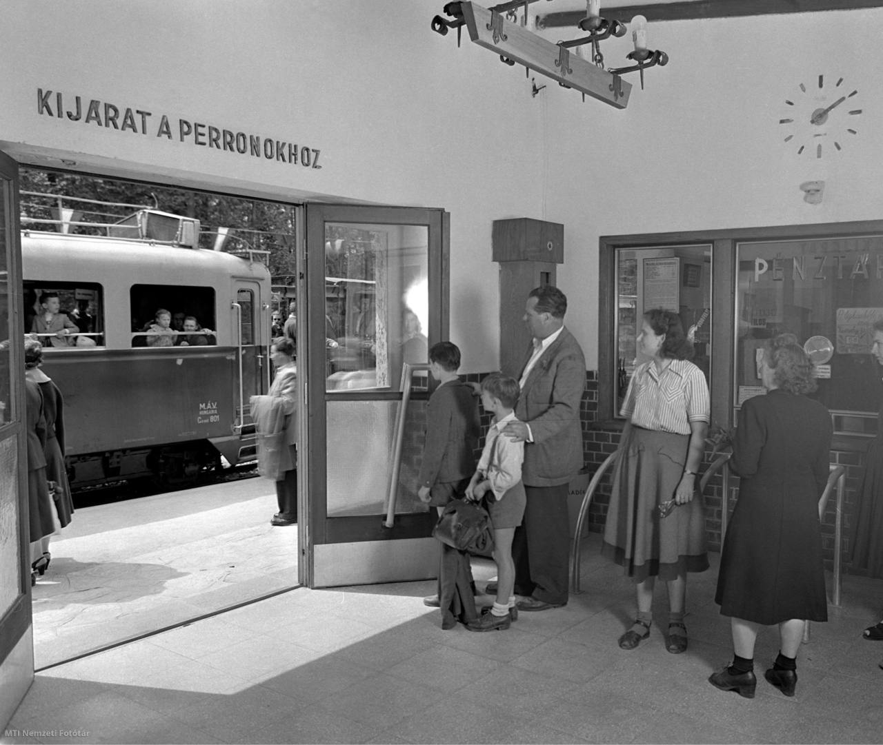 Budapest, 1954. április 27. Utasok állnak a pénztár előtt az Úttörővasút Széchenyi-hegyi várótermében. A falon „Kijárat a peronokhoz” felirat