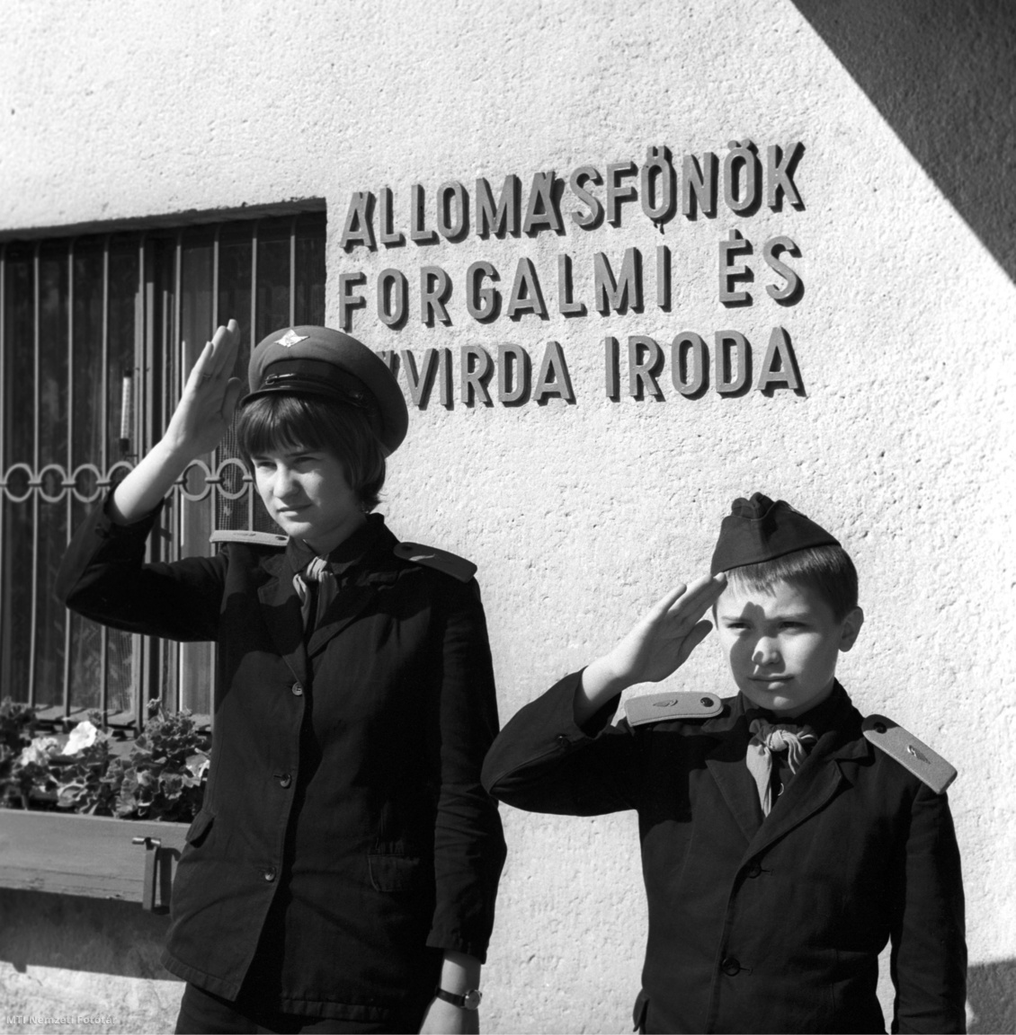 Az 1969. július 2-án készült felvételen az Úttörővasút gyermekvasutasai tisztelegnek az érkező kisvonatnak az állomásfőnök forgalmi irodája előtt