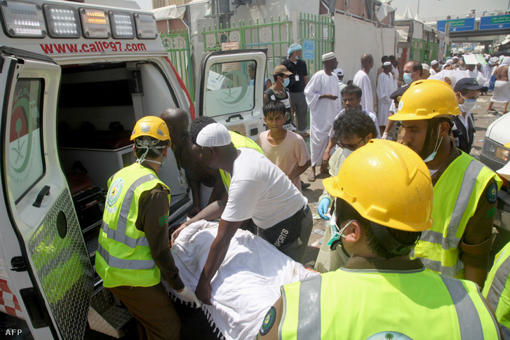 A szaúdi katasztrófavédelem személyzete és a haddzs zarándokai egy sebesültet raknak be egy mentőautóba a Mekka szent városa melletti Minában 2015. szeptember 24-én Szaúd-Arábiában